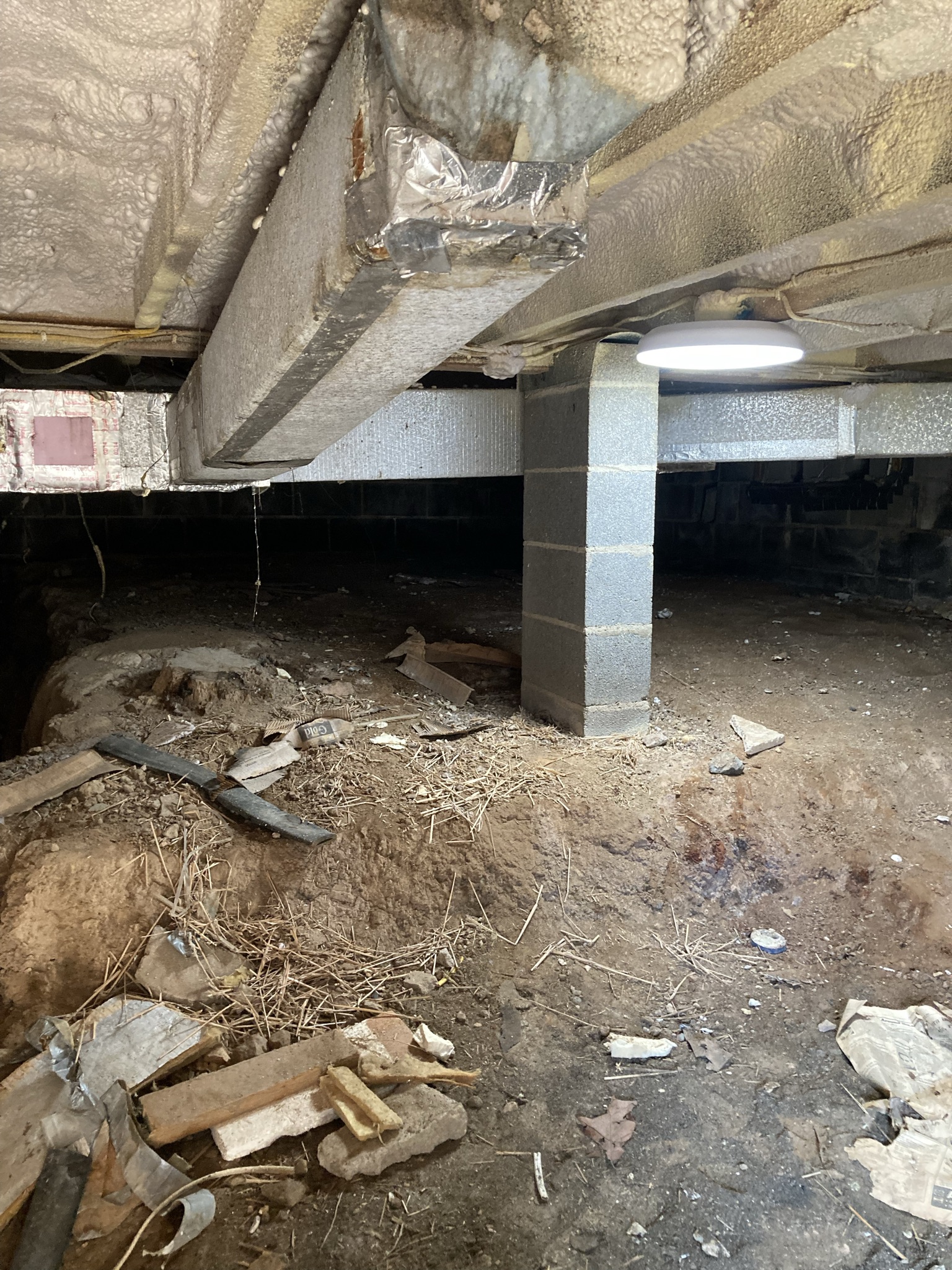 Uneven sloped earth of crawlspace.